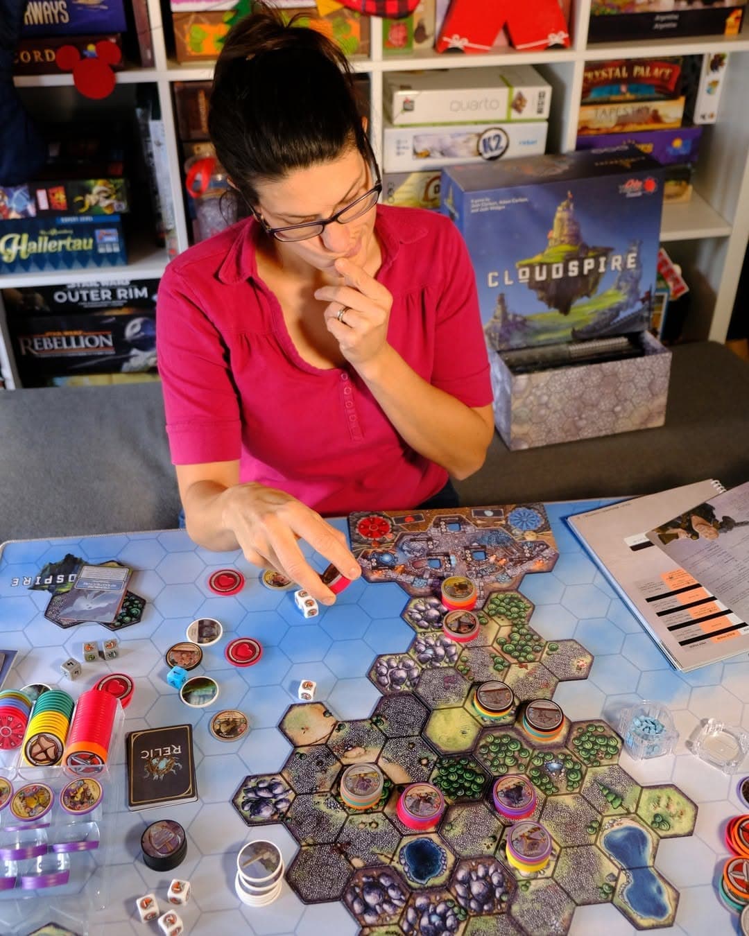 Playing Cloudspire board game with collection in background